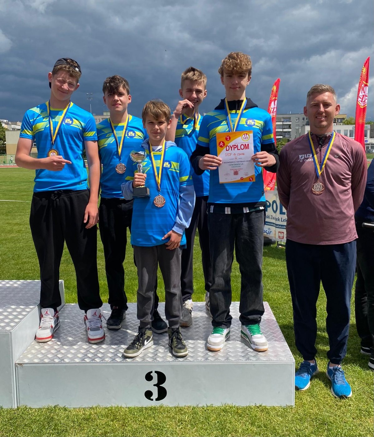 Drużyna chłopców z dyplomami i medalami na podium
