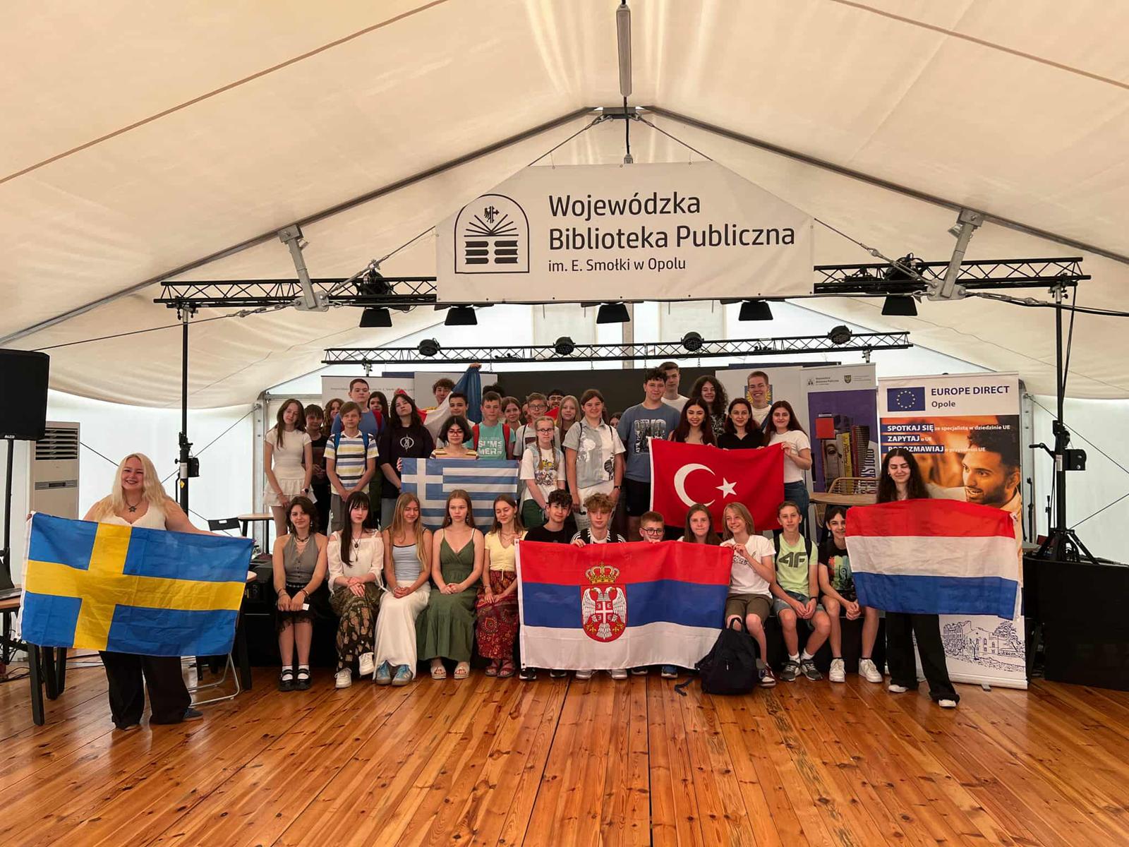 Zdjęcie grupowe na scenie w namiocie przy Wojewódzkiej Bibliotece Publicznej