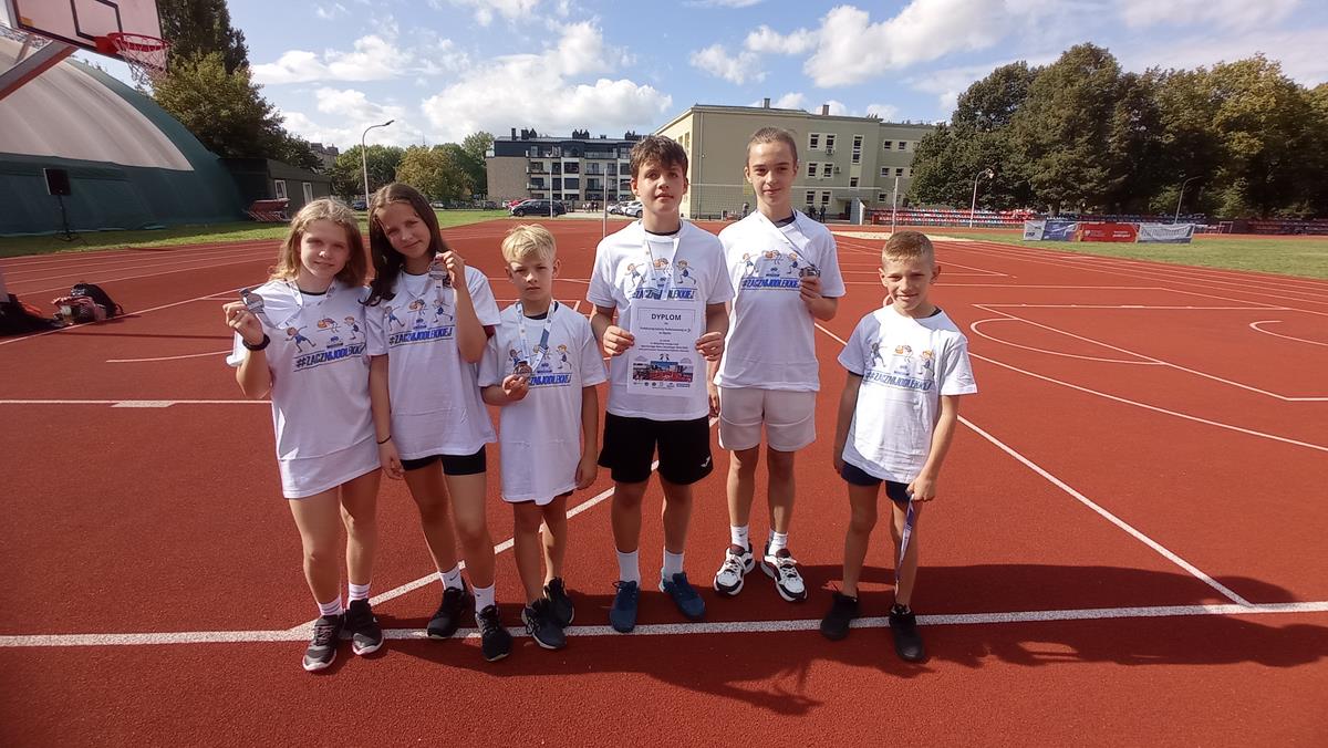 Zawody lekkoatletyczne - grupowe zdjęcie uczniów z medalami