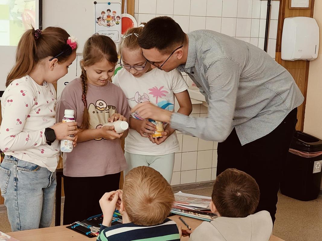 Trzy uczennice oraz dietetyk sprawdzają zawartość składników w jogurtach pitnych